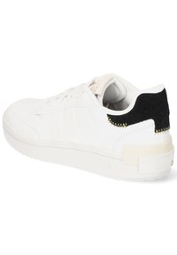 White sneaker with smooth leather upper, three side stripes, a black textured heel accent, and a cushioned white rubber sole.