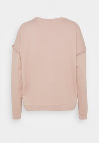 Felpa rosa chiaro realizzata in materiale morbido, con maniche lunghe, decorata con dettagli in pizzo sulle spalle e un colletto rotondo.