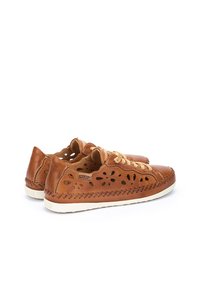 Chaussures en cuir marron avec un design perforé, des accents cousus et des lacets beige. Elles présentent une semelle en caoutchouc plate pour un confort optimal.