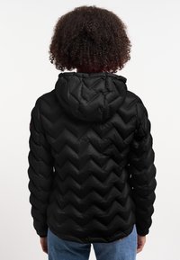 Giacca a vento nera con design a zigzag trapuntato e cappuccio. Il tessuto ha una texture liscia e la vestibilità è rilassata, con polsini elasticizzati.