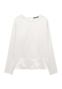 Blusa bianca a maniche lunghe in satin con scollatura rotonda e un sottile dettaglio a cucitura vicino all'orlo, esposta su uno sfondo bianco semplice.