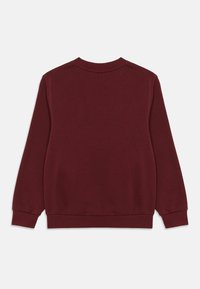 Bordó pulóver kerek nyakkal, bordázott mandzsettákkal és szegéllyel. A szövet lágy hatású, sima textúrájú, látható minták vagy díszítések nélkül.