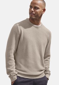Beige Strickpullover mit strukturierter Oberfläche, Rundhalsausschnitt und geripptem Saum. Lange Ärmel, lockere Passform, aus weichem Stoff gefertigt.