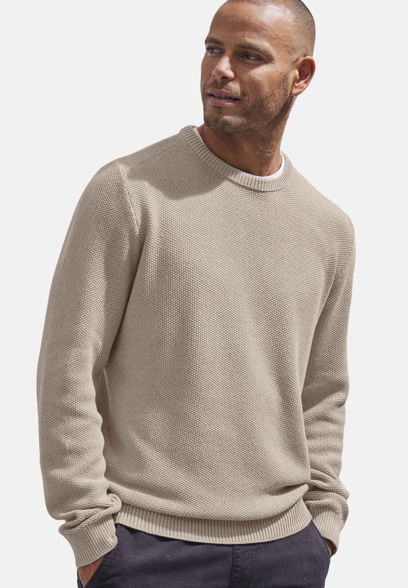 Beige Strickpullover mit strukturierter Oberfläche, Rundhalsausschnitt und geripptem Saum. Lange Ärmel, lockere Passform, aus weichem Stoff gefertigt.