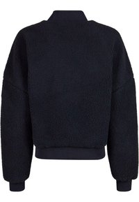 Felpa nera in pile con una superficie texturizzata e morbida, vestibilità oversize e polsini e orlo a coste. Presenta un colletto alto e arrotondato.