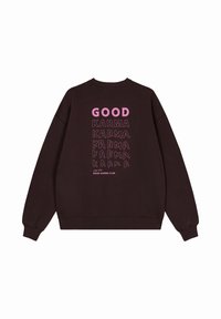 Sudadera marrón oscuro con un gran texto rosa y negro en la parte trasera que dice "GOOD KARMA" en varios estilos y fuentes.
