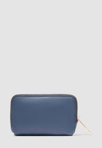 Portafoglio in pelle blu con angoli arrotondati e cerniera dorata sul lato destro, su sfondo grigio chiaro.