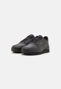 Sneaker sportive nere con tomaia in pelle liscia, dettagli testurizzati e suola imbottita per il comfort. Dotate di un sistema di allacciatura tradizionale.