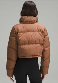 Chaqueta acolchada corta marrón con un cuello alto y acolchado horizontal. Textura suave y brillante, con grandes secciones acolchadas y puños elásticos.