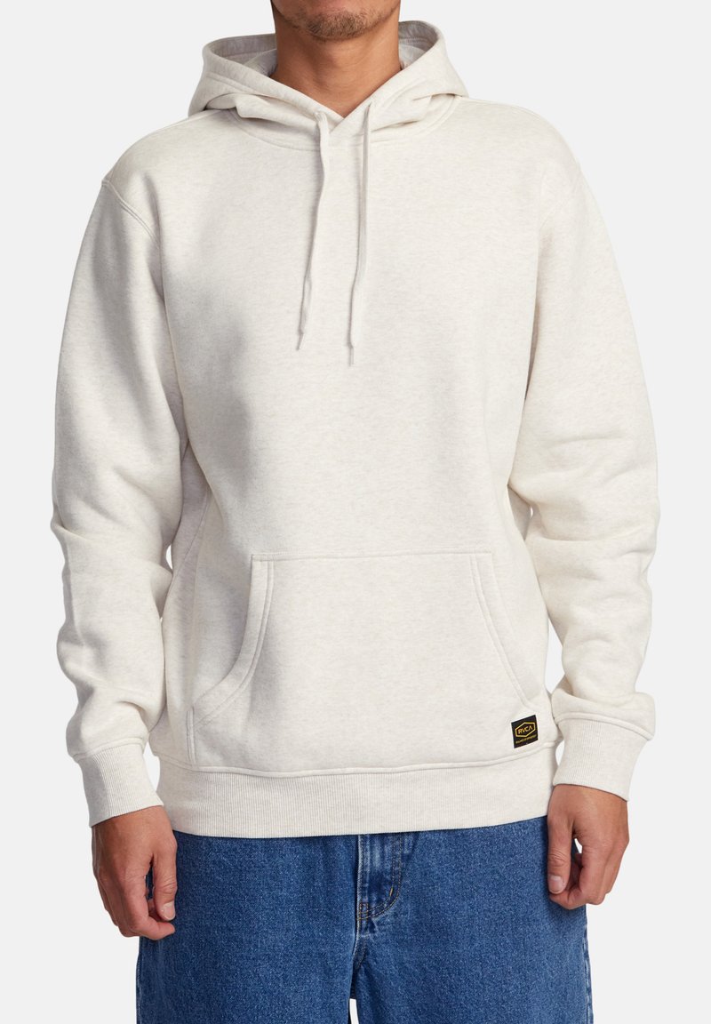 Haut à capuche blanc en tissu doux, avec une poche frontale, un cordon de serrage à la capuche, des poignets côtelés et une petite étiquette de logo à l'ourlet.