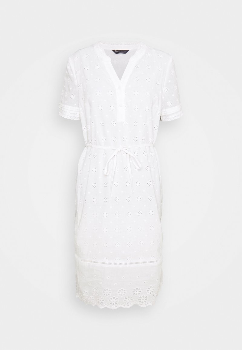 Weißes Baumwollkleid mit bestickten Augenlet-Dekoren, kurzen Ärmeln, Knopfleiste und Zugband in der Taille. Zackenförmiger Saum.