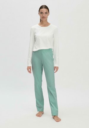 Langärmliges weißes Oberteil und mintgrüne Hose mit elastischem Bund, die einen lockeren Schnitt und eine glatte Stofftextur aufweist.