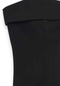 Juoda be petnešų palaidinė su struktūrizuota, sulenkta iškirpte, lygiu audinio paviršiumi ir švariais siūlais šonuose.