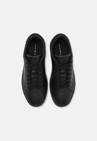 Sneaker in pelle nera con punta rotonda, design flat con lacci, accenti a logo in contrasto e colletto imbottito per maggiore comfort.