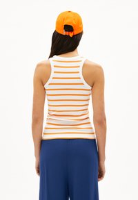 Gestreiftes Tanktop in Weiß und Orange, mit einer figurbetonten Passform und geribbelter Textur. Kombiniert mit einer passenden orangefarbenen Baseballmütze.