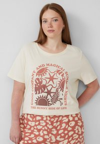 Crème-kleurig T-shirt met korte mouwen met een rode grafische afbeelding met zon- en plantenmotieven, en de tekst "GOEDE MAATSCHAPPIJ EN MAGISCHE ZOMERAVONDEN."
