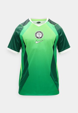 Nogometni dres Nogometne zveze Nigerije z zelenim prelivom in vzorcem črnih pik, belo ovratnico in robovi na rokavih ter logotipom Nike na prsih.