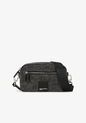 Pelēka auduma crossbody soma ar rāvējslēdzēja aizdari, logotipa plāksteri un regulējamu siksnu, kurā ir iespiesti „KARL LAGERFELD” detalizējumi.