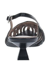 Sandalo in pelle nera con design a ritaglio, cinturino alla caviglia regolabile, tacco basso e rivestimento interno morbido. Superficie esterna texturizzata.