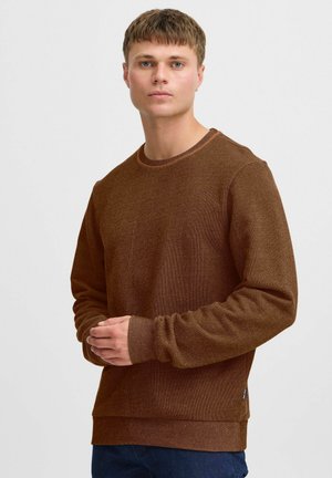 Sudadera marrón con textura, de manga larga, cuello redondo y puños de canalé. Detalle de costura notable a lo largo del escote.
