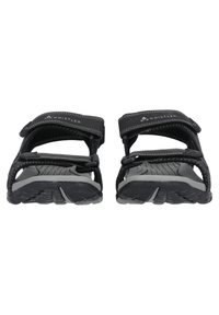 Mustat sandaalit, joissa on harmaat pohjat, varustettu säädettävillä remmeillä, teksturoiduilla jalkapohjilla ja pyöristetty nenämuoto. Brändäys näkyvissä remmillä.