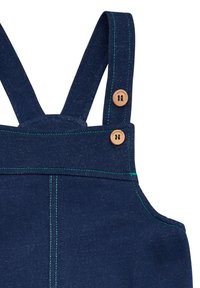 Salopette blu navy con bretelle ampie, cuciture verdi e bottoni in legno. Il tessuto ha un aspetto texturizzato e un design strutturato.
