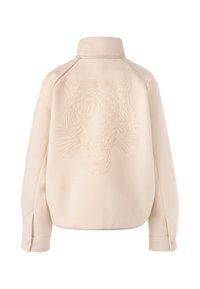 Cream-colored oversized jacket with a textured finish, featuring an embroidered tiger design on the back and buttoned cuffs.