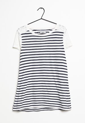 Camiseta de rayas con franjas horizontales azul marino y blancas, mangas cortas de encaje, escote redondo y corte holgado. Colgada de un gancho negro.