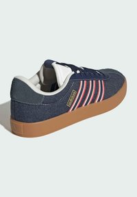 Navy denim sneaker with gum rubber sole, white and red striped accents, round lace-up design, and padded collar for comfort.