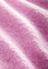 Tissu rose pâle avec une texture duveteuse et bouclée, et des plis doux créant des contrastes de lumière et d'ombre.