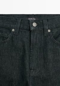 Černé džíny z denimu s pěti kapsami, s kovovým zapínáním a značkovou nášivkou na pase.