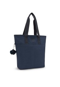 Granatowa torba na ramię z teksturowanego materiału, z dwoma mocnymi ramiączkami, okrągłym logo oraz dekoracyjnym chwostem z futra przymocowanym z boku.