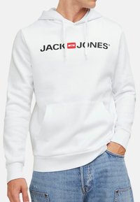 Hvid hoodie med et stort sort "JACK & JONES" logo, snore og en kengurulomme. Blødt stof med ribbede manchetter og kant.