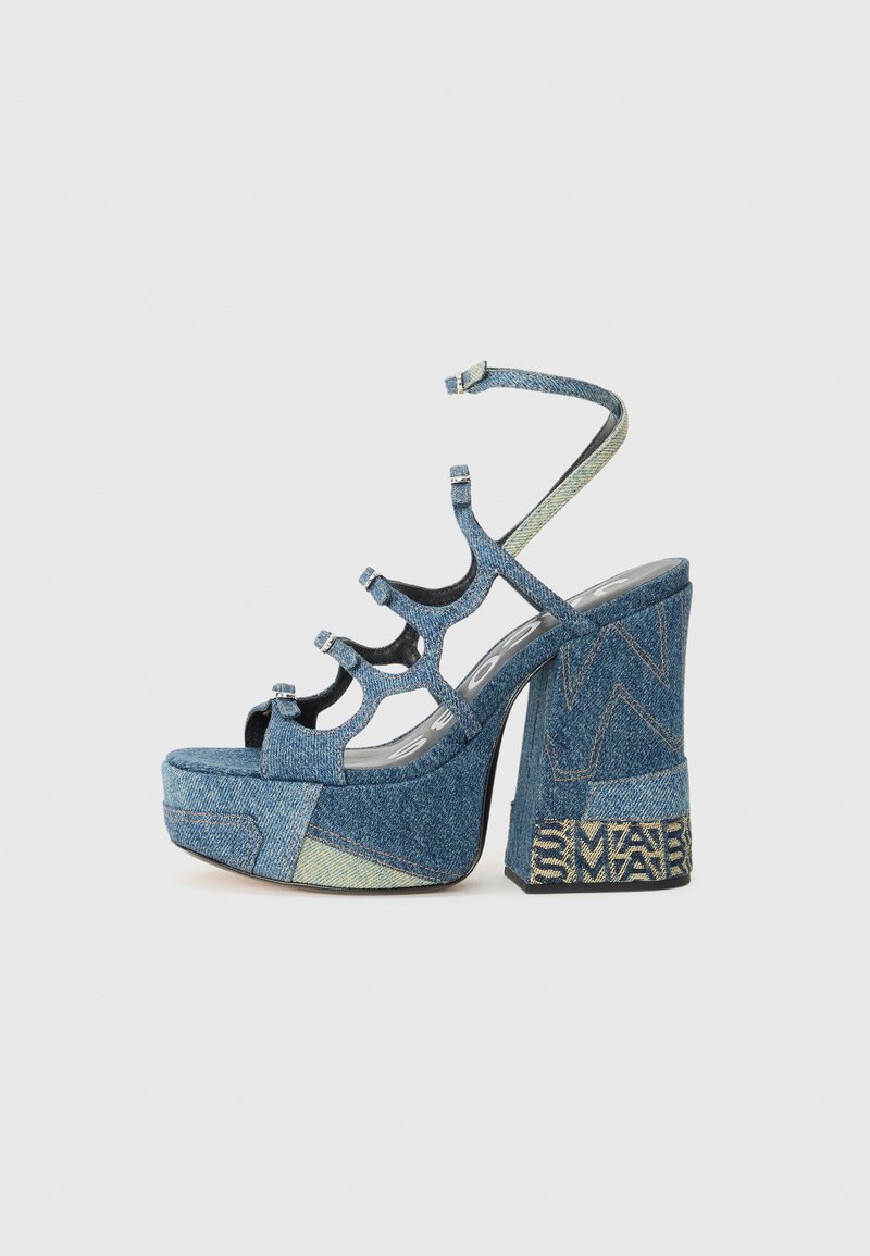 Denim platform sandals with a chunky heel, featuring multiple straps, peep-toe design, and patterned accents on the heel.