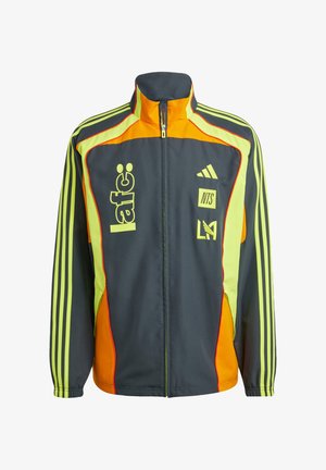 Tumši pelēka sporta jaka ar dzelteniem un oranžiem akcentiem. Iezīmē augstu apkakli, rāvējslēdzēja priekšpusi un trīs svītru dizainu uz piedurknēm. Ietver logo.