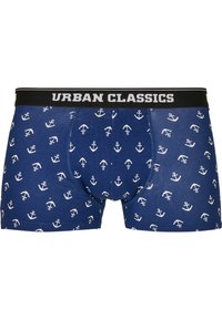 Navyblaue Boxershorts mit einem weißen Ankerdesign, ausgestattet mit einem schwarzen Bund, auf dem "URBAN CLASSICS" in weißem Text gedruckt ist.