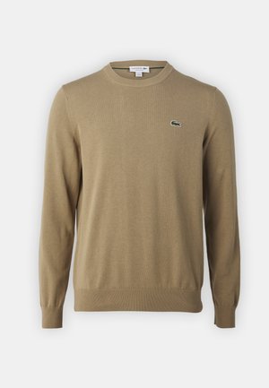 Maglione in maglia beige con collo a giro, polsini e orlo ribattuti, con un piccolo logo verde Lacoste sul petto. Tessuto morbido, design casual.