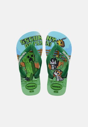 Grüne Kinder-Flip-Flops mit pixelartigen Minecraft-Charakteren und Text, mit einem Creeper, Hund und einer Biene auf strukturierten Sohlen.