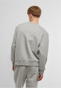 Gray sweatshirt featuring a crew neck, long sleeves, and a relaxed fit. Made of soft fabric with ribbed cuffs and hem for added texture.