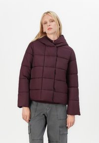 Giacca imbottita viola con cappuccio, caratterizzata da un design squadrato e quadrati cuciti. Maniche lunghe e silhouette corta.