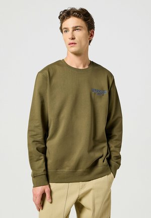 Olivegreenowa bluza wykonana z tkaniny bawełnianej, z okrągłym dekoltem i niebieskim logo "WRANGLER" na lewej piersi. Długie rękawy.