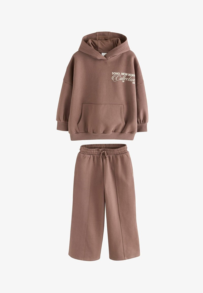 Sweat à capuche marron avec poche devant et pantalon large assorti avec taille élastique, ensemble décontracté deux pièces avec impression de texte sur la poitrine.