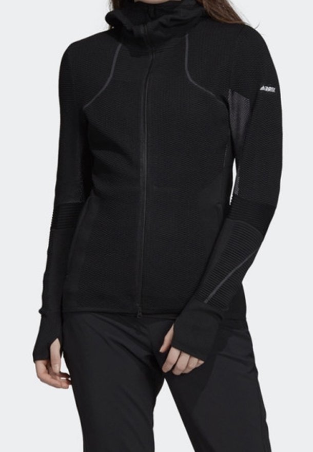 Veste zippée noire à manches longues en tissu texturé, col montant et passe-pouces. Présente un design à panneaux contrastés et une coupe ergonomique.