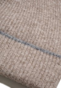 Beidzis adīšanas audums ar rievotu tekstūru un pelēku horizontālu svītru. Mīksts un biezs, piemērots siltuma un komforta nodrošināšanai.