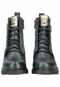 Bottines en cuir noir avec une texture robuste, présentant des détails métalliques et des clous décoratifs, fermées par des lacets et une fermeture éclair sur le côté.