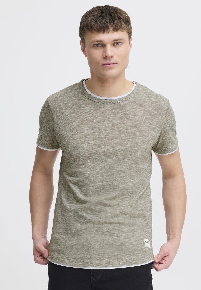 Tricou texturat de culoare verde măslinie, cu guler rotund, mâneci scurte și accente albe la guler și la tivul mânecilor. Etichetă mică a brandului la tiv.