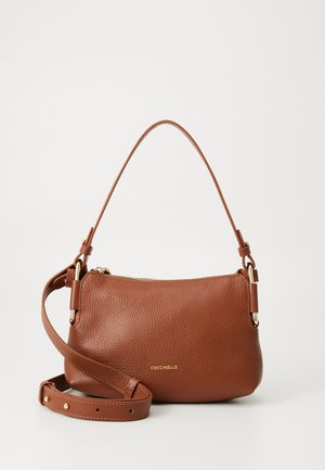 Brown textured leather handbag with gold-tone zipper, adjustable shoulder strap, and short handle, branded with "COCCINELLE" in gold letters.