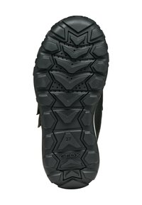 Suela de zapato de goma negra con profundos surcos en zigzag, pequeñas perforaciones, talla 27 y el nombre de la marca "GEOX" grabado cerca del talón.
