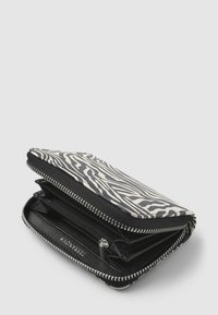 Portfel w czarno-kremowy wzór zebry, z metalowym zamkiem błyskawicznym i wieloma wewnętrznymi przegródkami na karty i gotówkę. Wykonany z trwałego materiału.