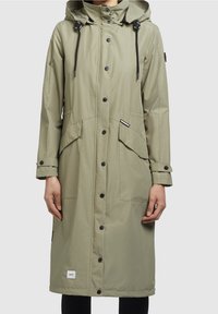 Imperméable long vert olive, fabriqué en tissu lisse et résistant à l'eau. Comprend une capuche, des boutons-pression, deux grandes poches avant et des poignets ajustables.